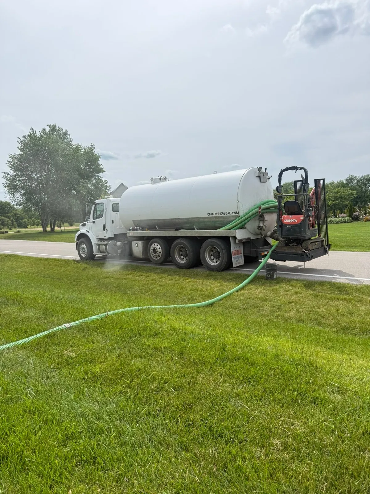 Pump hose running across a lawn to the tank