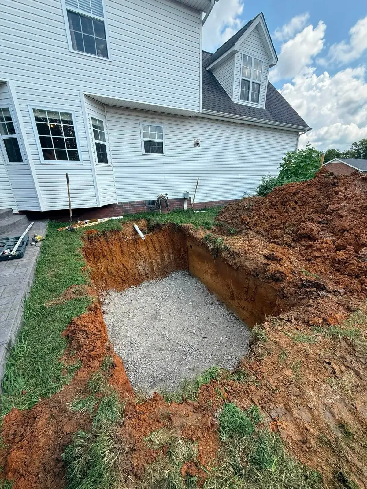 Excavated septic tank pit lined with gravel on a new installation