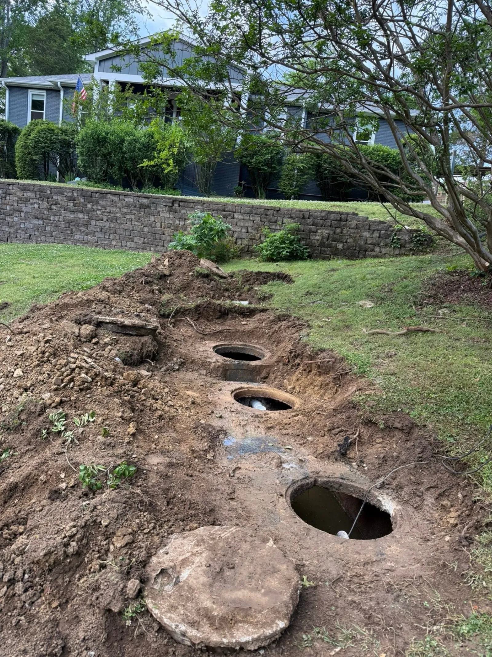 Three concrete septic tank lids uncovered in a trench during a service call